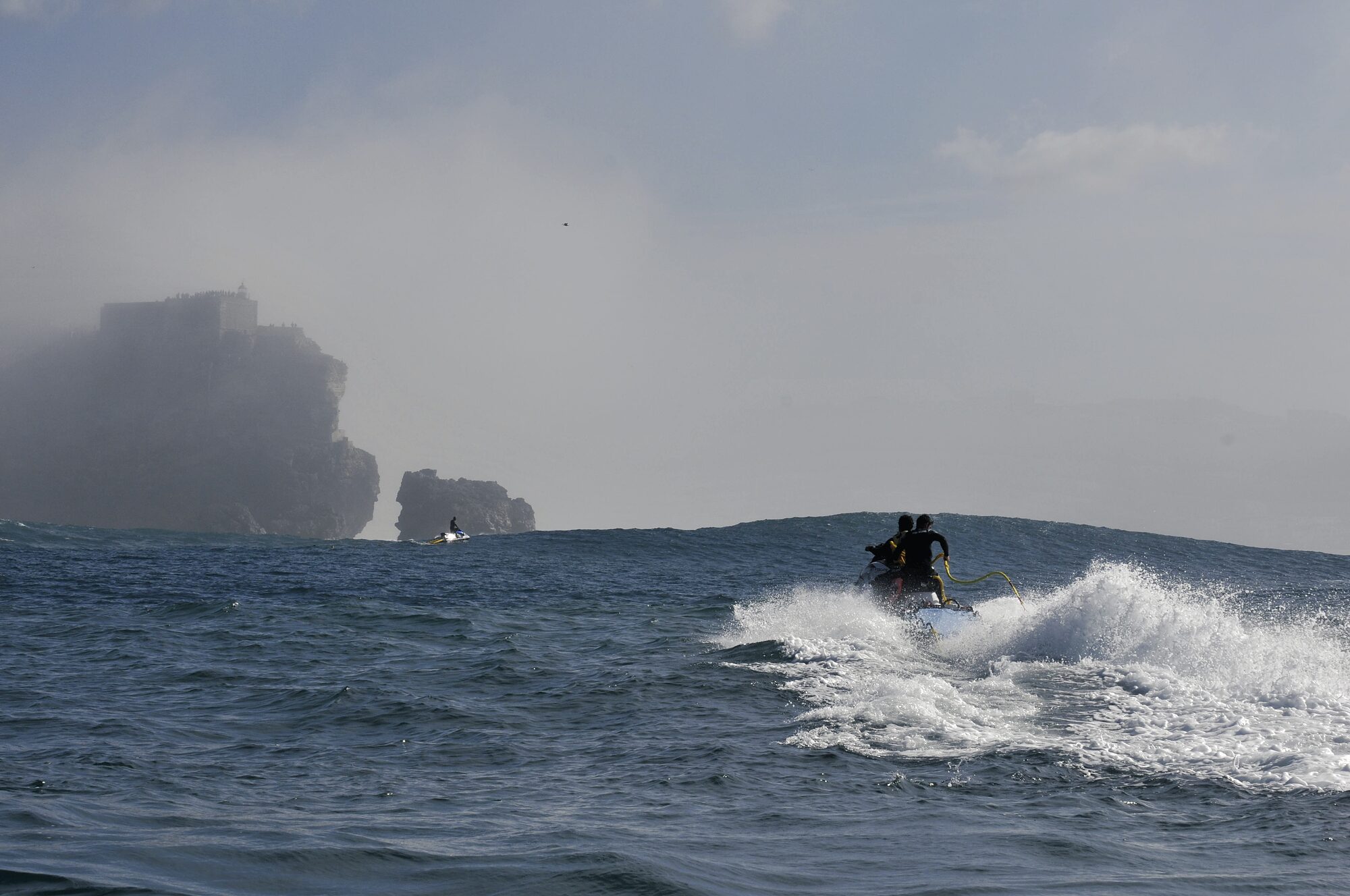 Atlantic Safaris jet ski heading through the white water at Praia do Norte towards the Nazaré lighthouse